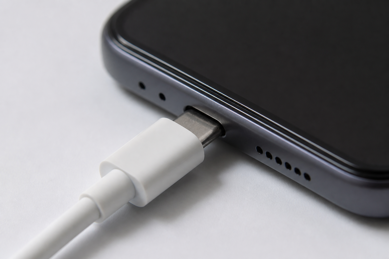 Cable USB-C conectado al puerto de carga de un iPhone