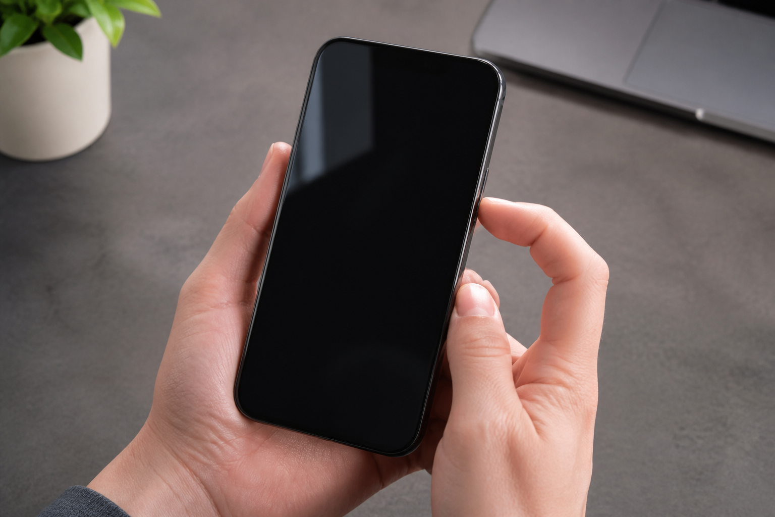 iPhone con pantalla negra sostenido en la mano